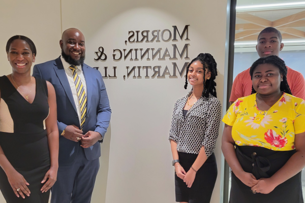 Three high school interns meet with Andrew O. Clarke (second from right), managing partner at District Legal Group, and Shanellah Verna Harris (far right), 莫里斯, 曼宁 & 马丁副.